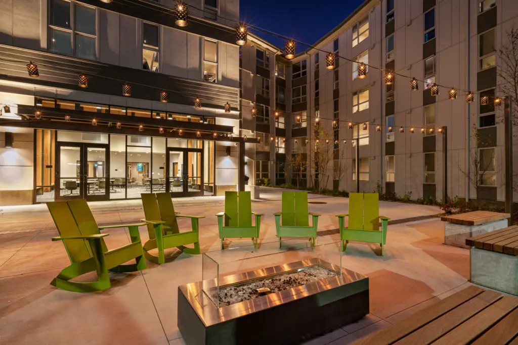 Alder Residence Hall courtyard in the evening with string lights and a fire pit